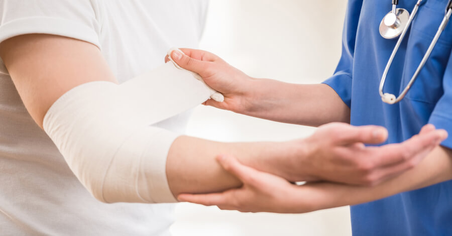 Doctor haciendo un vendaje en el codo a un paciente