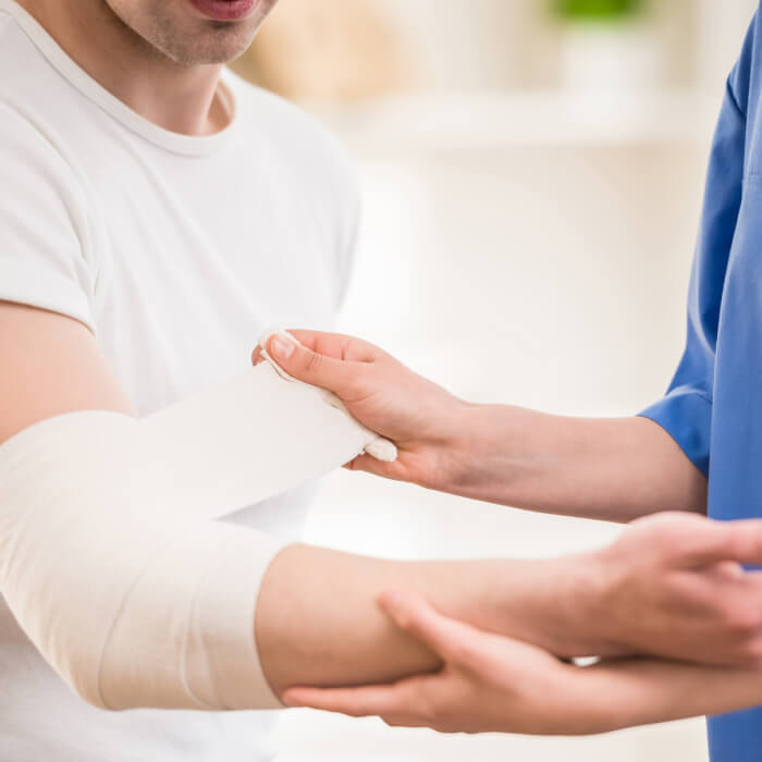 Doctor haciendo un vendaje en el codo a un paciente